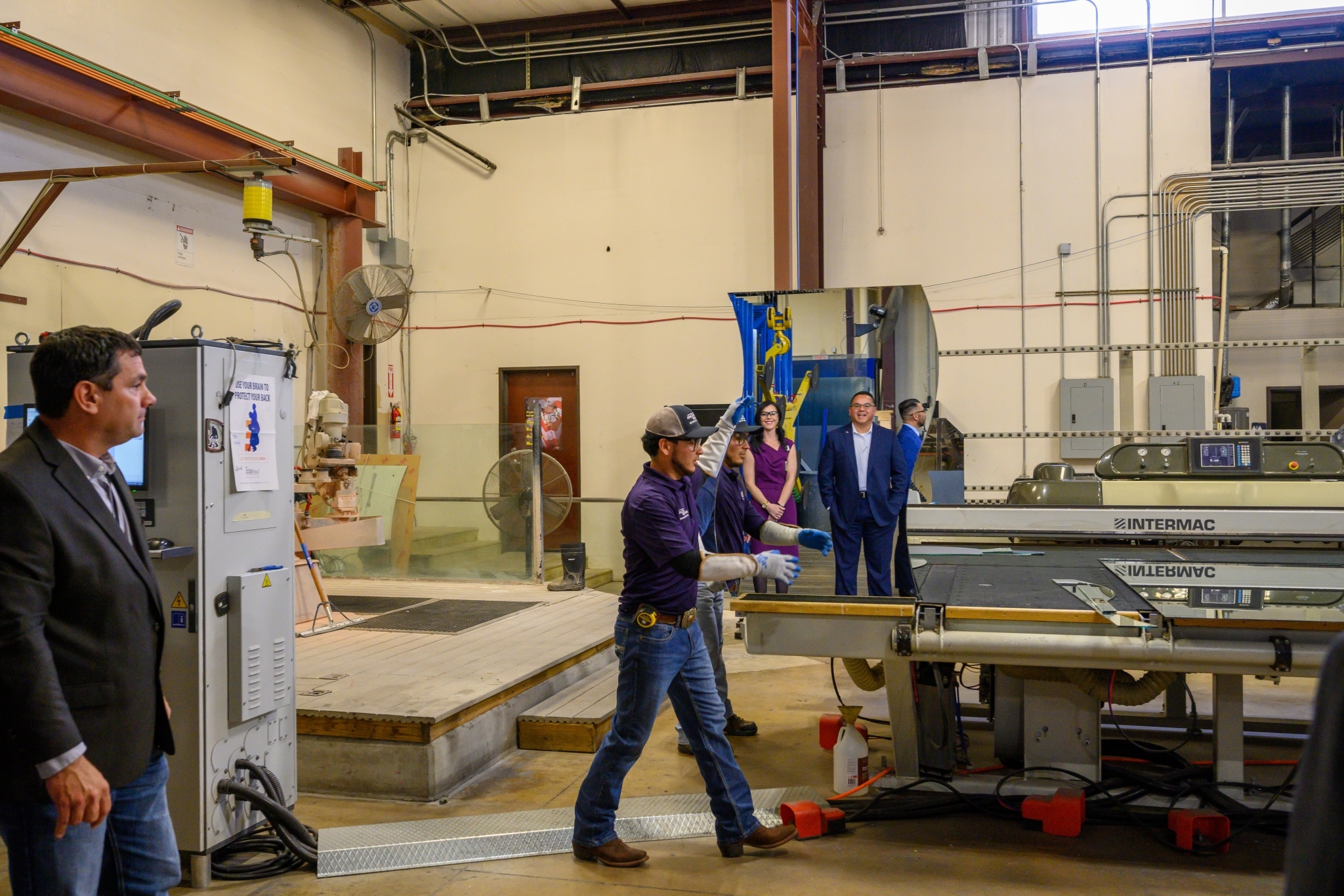 Rene Flores, WSRCA Board Treasurer, City of Round Rock Councilman, and Vice President and Commercial Loan Officer with Amplify Credit Union, and Regina Munson, Director of Business Development with Anchor-Ventana Glass, watch the demonstration of the glass production process